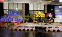 Der Livestream ins Studio des Digital Social Summit mit zwei Personen, die auf einem Podium sitzen und sich unterhalten. Links das Motto der Veranstaltung: übermorgen
