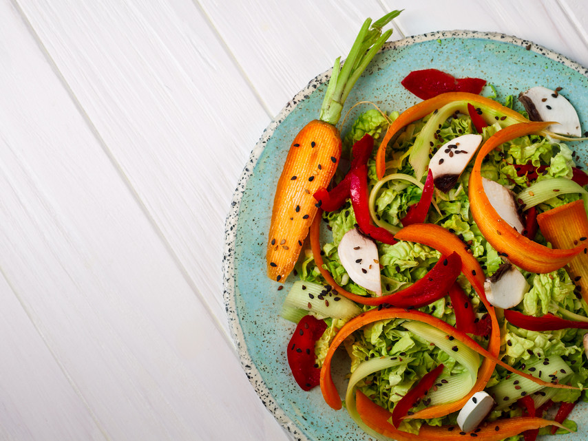 frisches Gemüse und Salat mit Karotten und Pilzen auf einem Teller