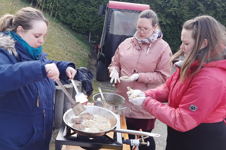 Personen beim Kochen draußen