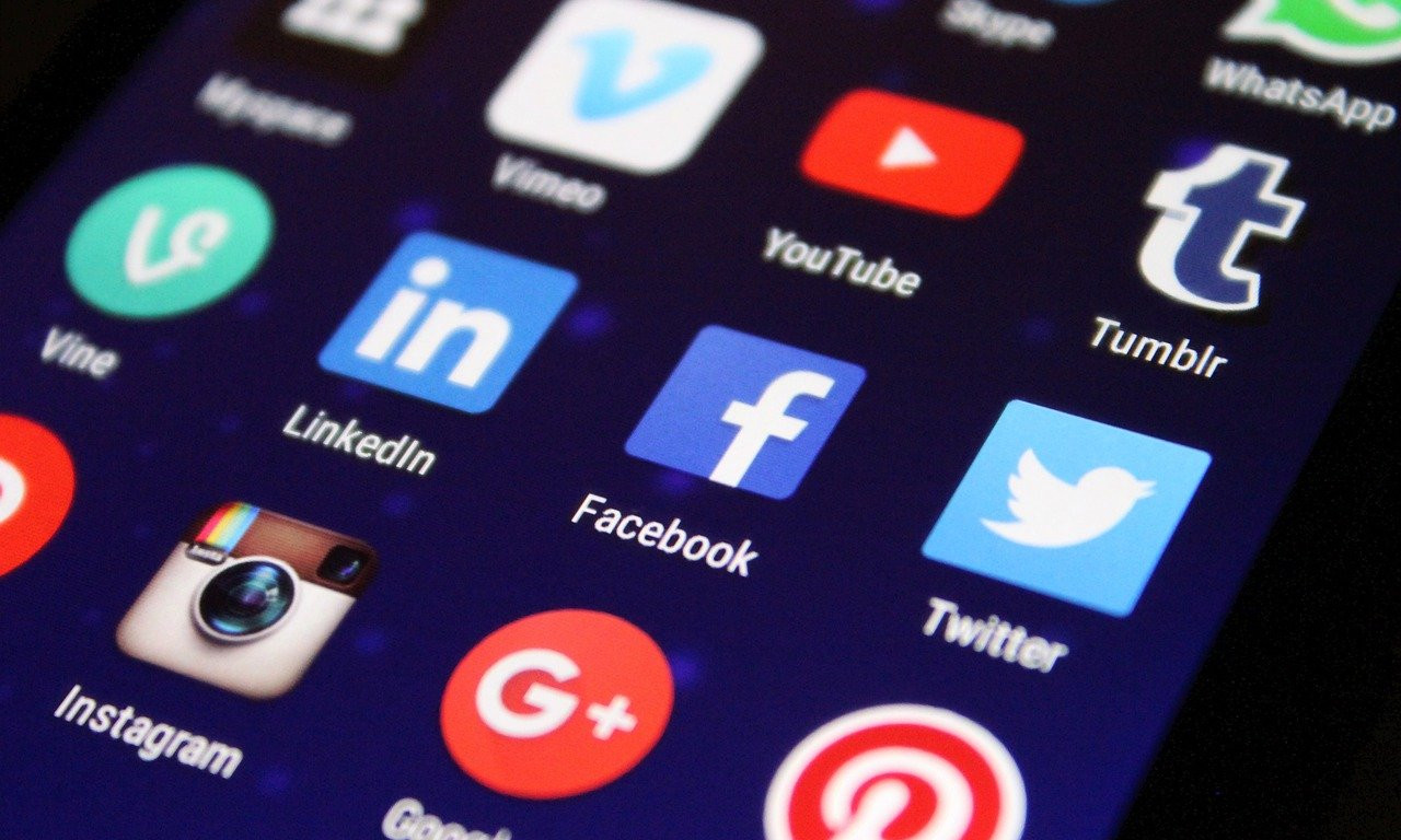 Ein Smartphone zeigt den Startbildschirm mit vielen App-Buttons wie Twitter, Facebook, YouTube uvm.