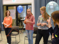 Vier Mitglieder der Social Innovation Community bei der Durchführung einer kreativen Workshop-Methode mit einem Bindfaden und Luftballons.