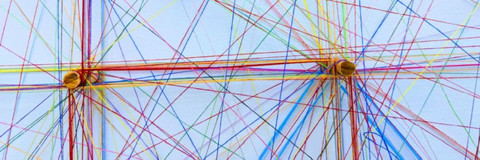 Darstellung von Vernetzung durch bunte gespannte Bindfaden