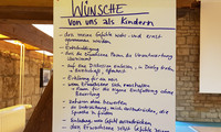 Ein Plakat mit handgeschriebenen "Wünschen von uns als Kindern"