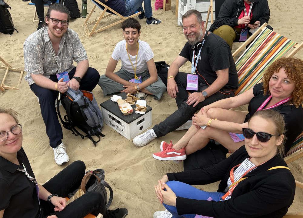Mehrere Menschen sitzen im Halbkreis für ein Gruppenfoto.