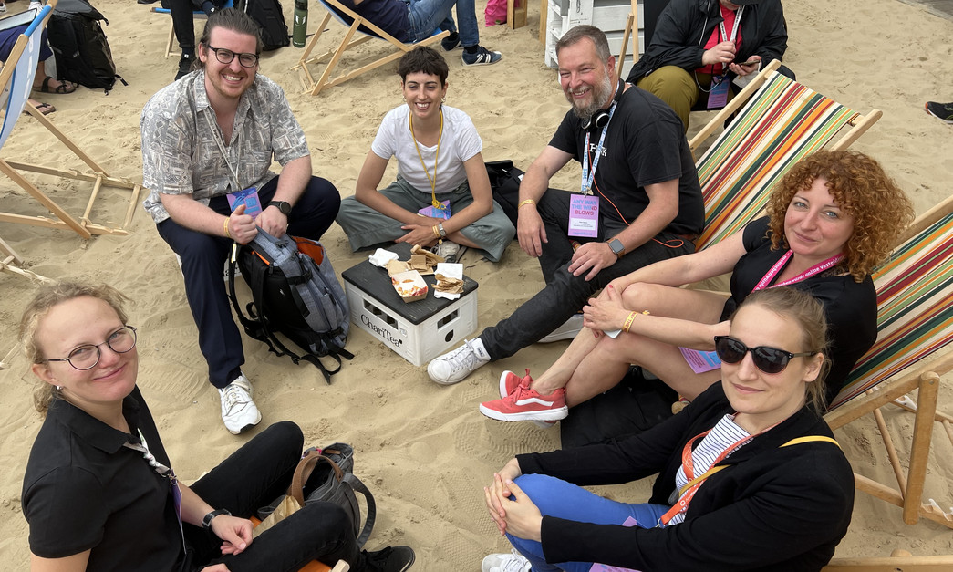 Mehrere Menschen sitzen im Halbkreis für ein Gruppenfoto.