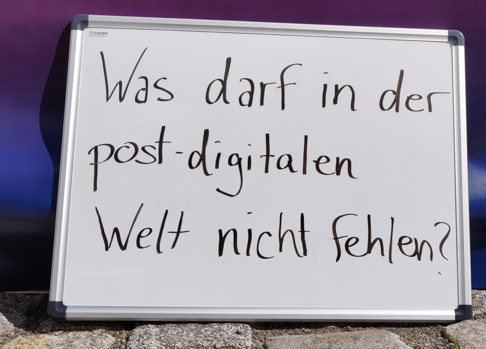 Ein Whiteboard auf dem steht: Was darf in der post-digitalen Welt nicht fehlen?