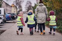 Kinder gehen mit Erzieherin spazieren