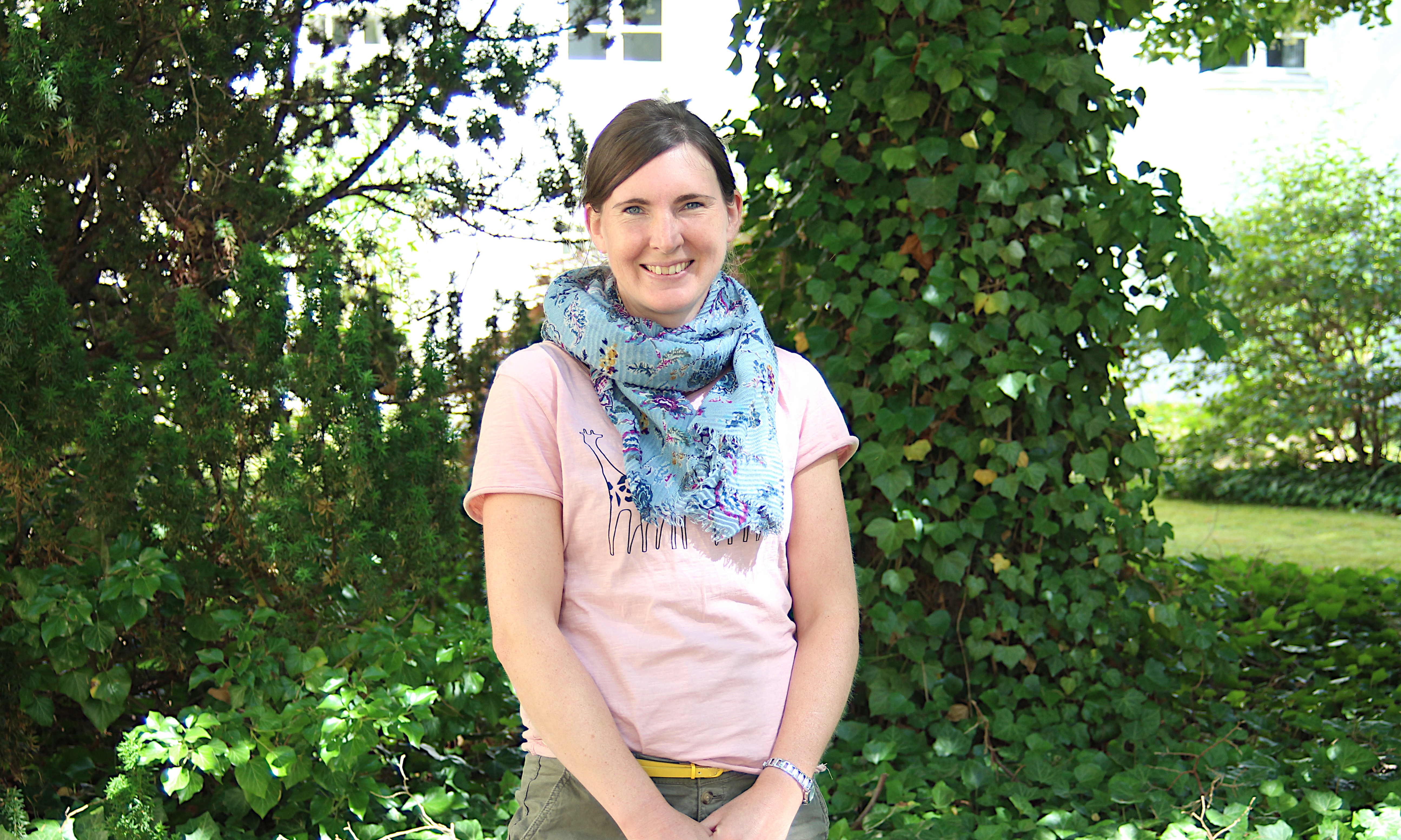 Beate Rottkemper steht im Freien vor grüner Natur