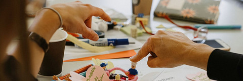 Prototyp mit Lego und Papier und zwei Händen, die darauf zeigen.