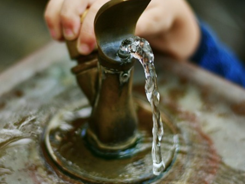 Kinderhand greift nach einem Wasserspender