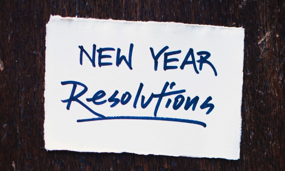 Blatt Papier auf dem "New Year Resolutions" steht.