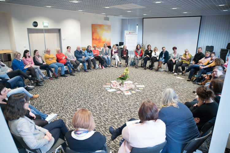 viele Menschen sitzen im Stuhlkreis