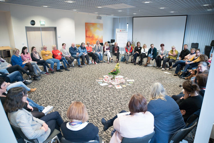 viele Menschen sitzen im Stuhlkreis