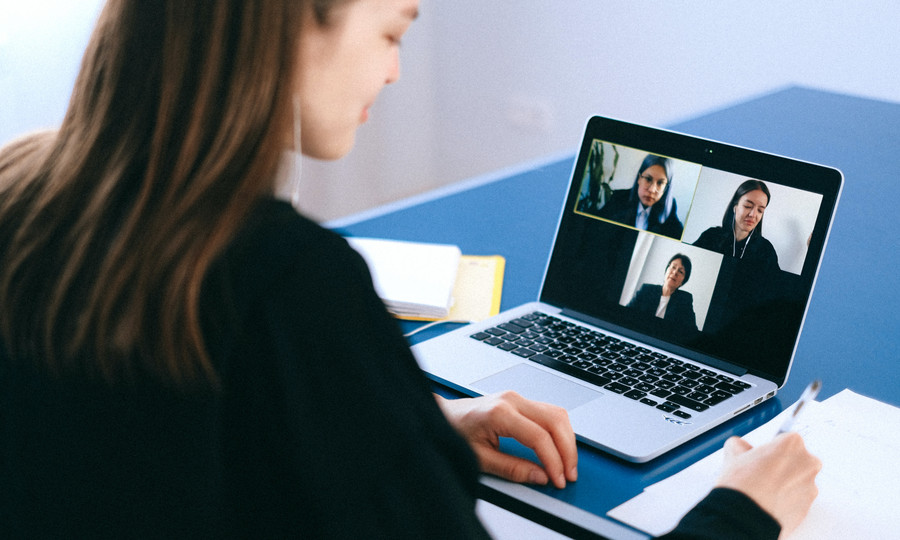 Mitarbeitende arbeitet remote am Laptop mit Team