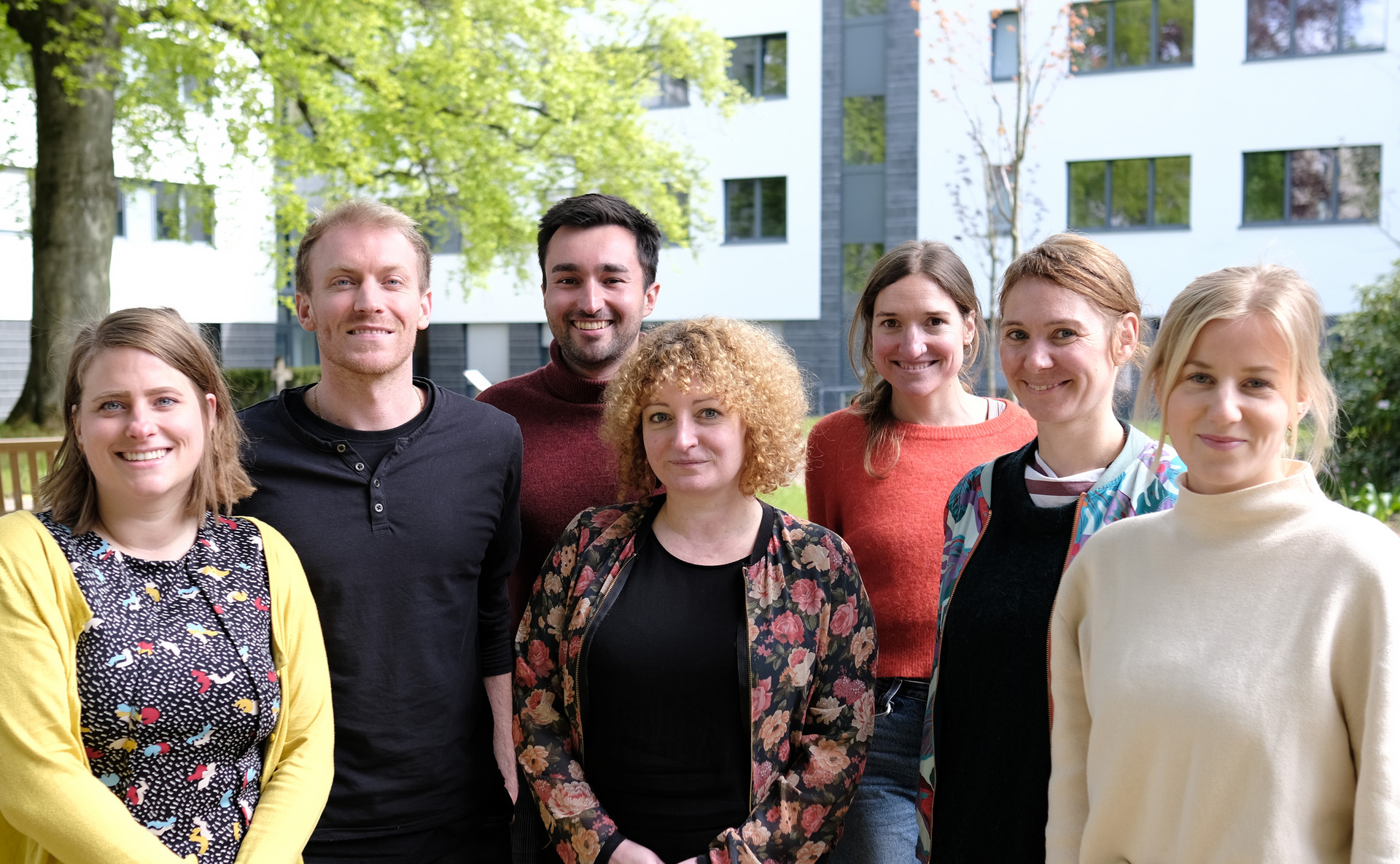 Mitglieder des Teams Digitalisierung steht im Freien vor dem DRK Generalsekretariat, umgeben von Bäumen und Grünflächen im