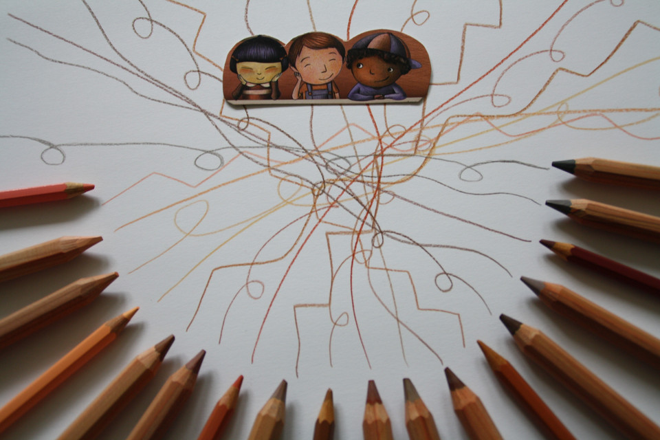 Familienzentrum Schönau Buntstifte liegen kreisförmig auf weißem Papier. In der Mitte verlaufen zahlreiche Linien in verschiedenen Farben, die von den Stiften ausgehen und sich kreuzen. Am oberen Rand sind zwei gezeichnete Kinderfiguren mit unterschiedlichen Hauttönen und Frisuren zu sehen.