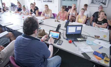 Eine Gruppe sitzt in einem Konferenzraum um einen Tisch.