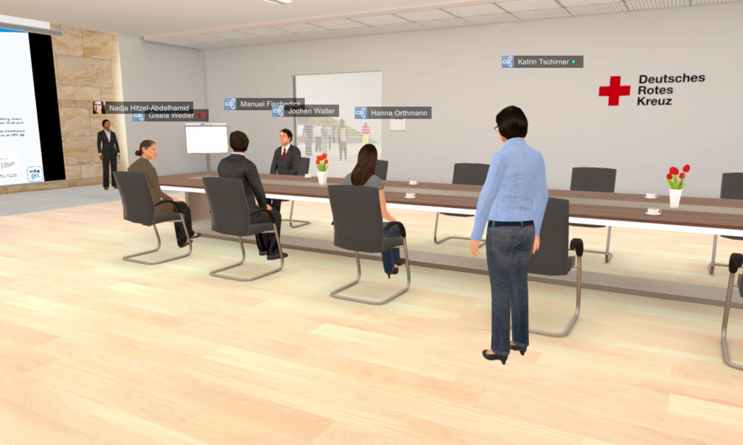 Ein Meetingraum in einer virtuellen 3D-Welt. Es wird das Migrationsberatungsprojekt mbeon vorgestellt. An der Wand ist das Logo des Deutschen Roten Kreuzes zu sehen. Mehrere Avatare verfolgen den Vortrag sitzend oder stehend.