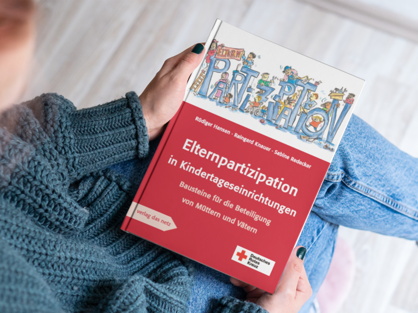 Hände halten Buch zu Elternpartizipation fest