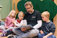 Erzieher liest Kindern vor