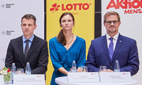 Sechs Personen stehen bei einer Pressekonferenz hinter drei Stehtischen mit weißen Hussen, im Hintergrund Banner von Deutschem Rotem Kreuz, Lotto, Aktion Mensch und Deutscher Fernsehlotterie.