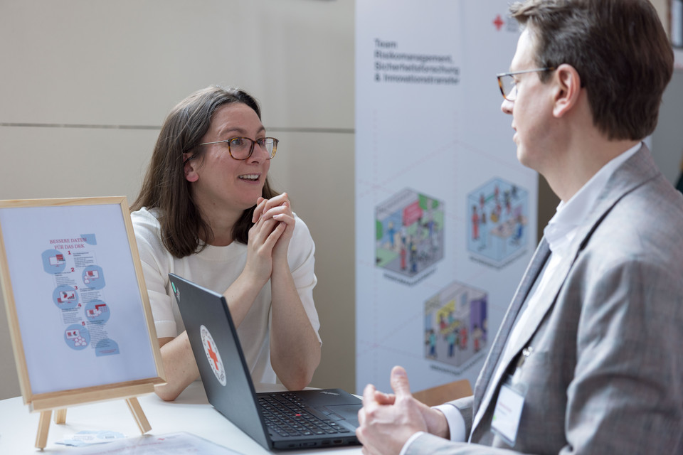 Hannah Lachenmaier (Referentin für Wirkungsmanagement) im Gespräch mit einem Teilnehmenden des WFK