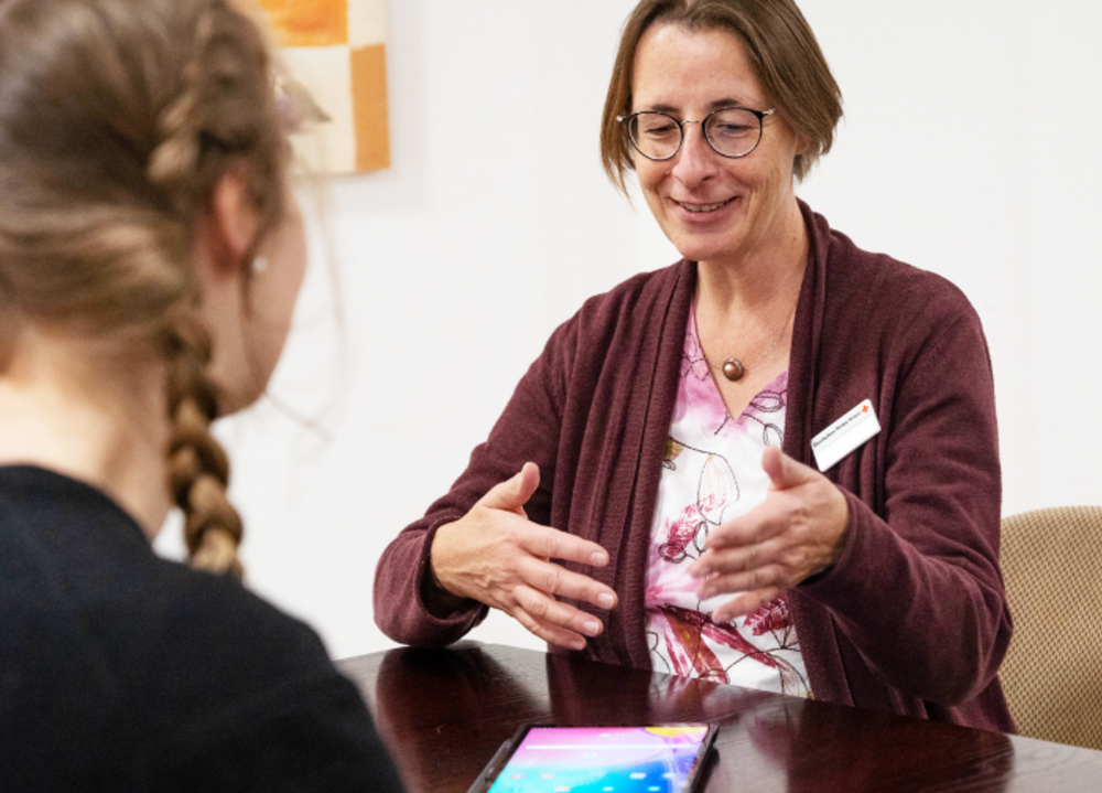 Mitarbeiterinnen des DRK sitzen am Tablet