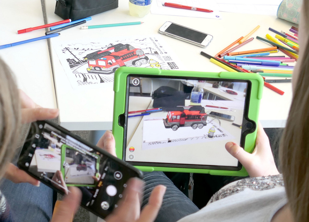 Zwei Kinder spielen mit Smartphone und Tablet in der Kita