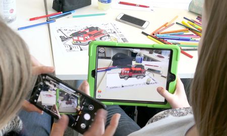 Zwei Kinder spielen mit Smartphone und Tablet in der Kita