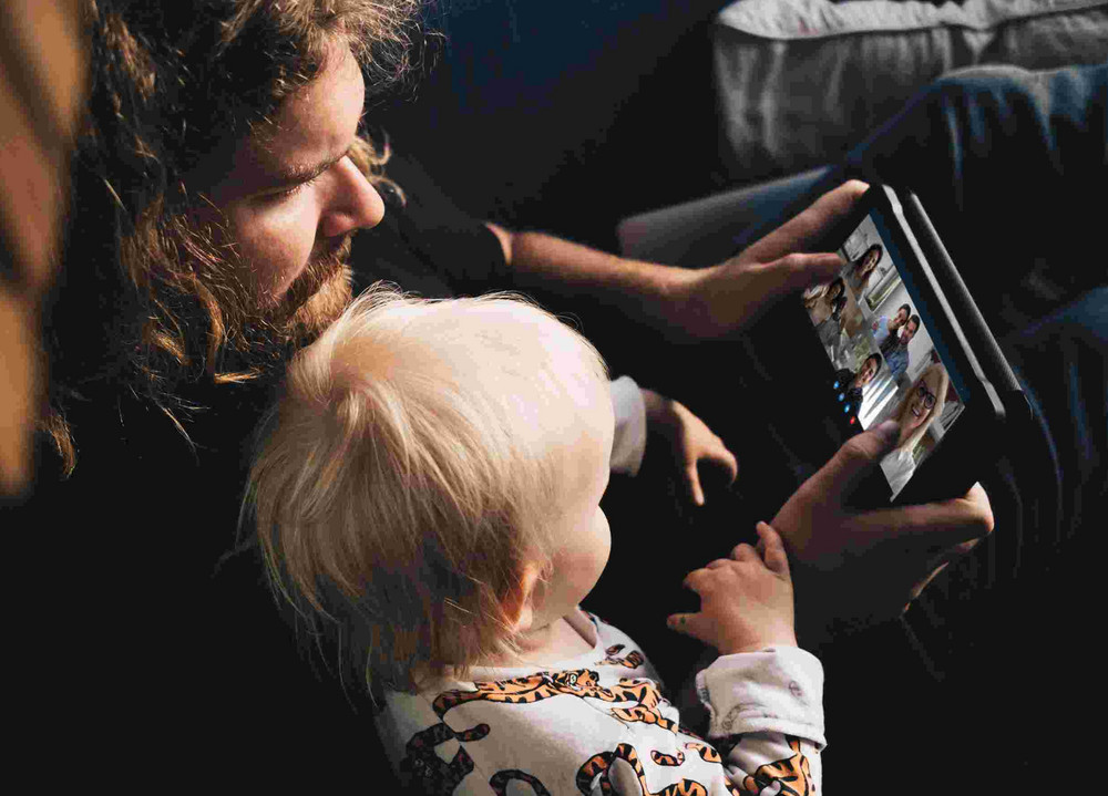 Vater und Sohn nehmen an einem virtuellen Kurs via Tablet teil