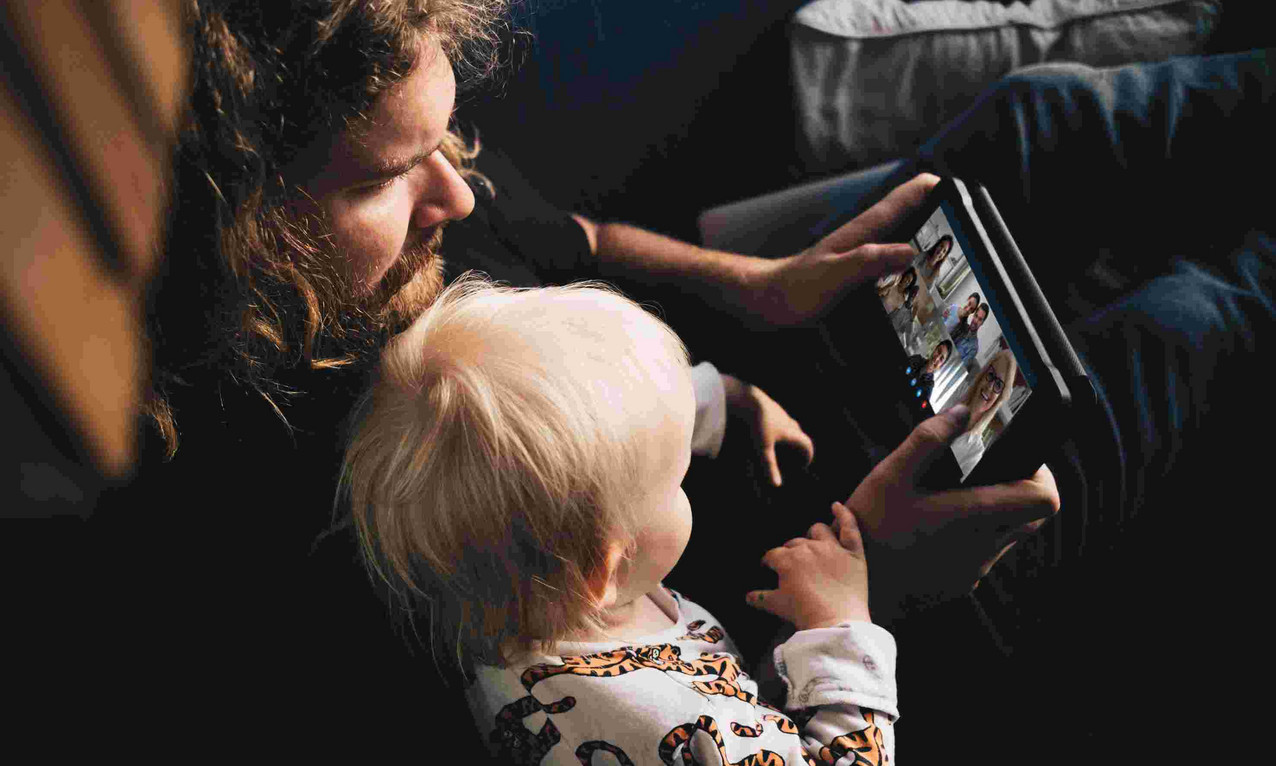 Vater und Sohn nehmen an einem virtuellen Kurs via Tablet teil