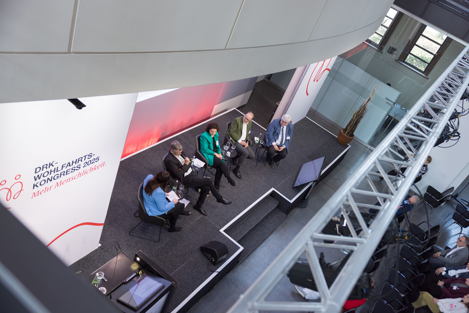 Vogelperspektive auf die Bühne, von links nach rechts: Karolina Molter (DRK-Generalsekretariat) Prof. Dr. habil. Thomas Klie (Evangelische Hochschule Freiburg) Dr. Carola Reimann (AOK-Bundesverband) Michael Ranft (DRK-LV Berlin) Thomas Petrak (DRK-KV Lichtenfels)