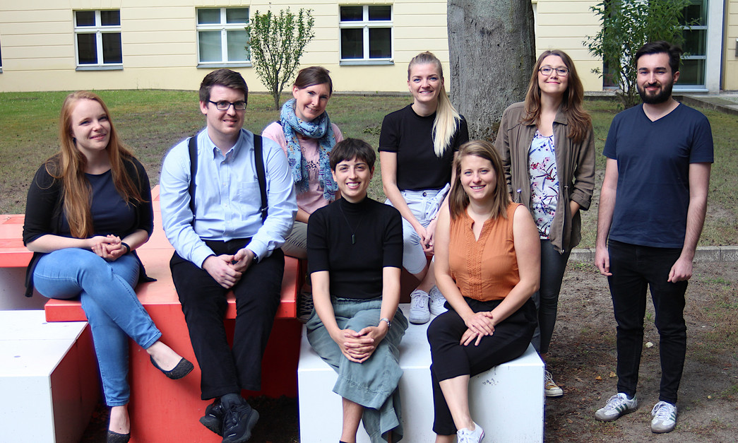 Ein Foto von 8 Personen im grünen Hinterhof des DRK-Gebäudes.