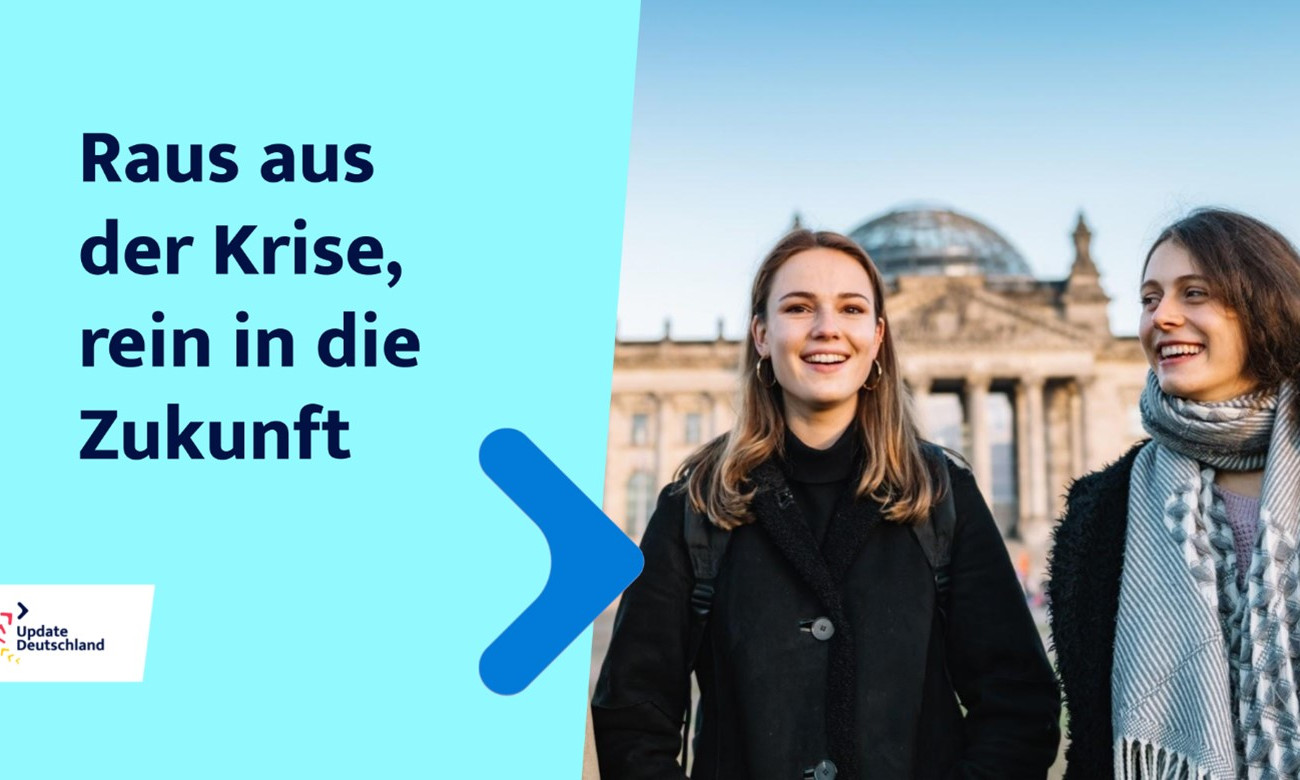 Links im Bild steht "Raus aus der Krise, rein in die Zukunft" - recht im Bild stehe zwei junge Frauen vor dem Reichstagsgebäude in Berlin.