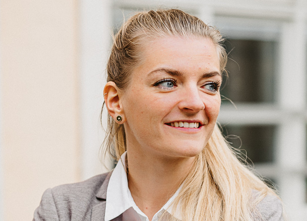 Das Bild zeigt Bettina Stuffer vor einem Gebäude