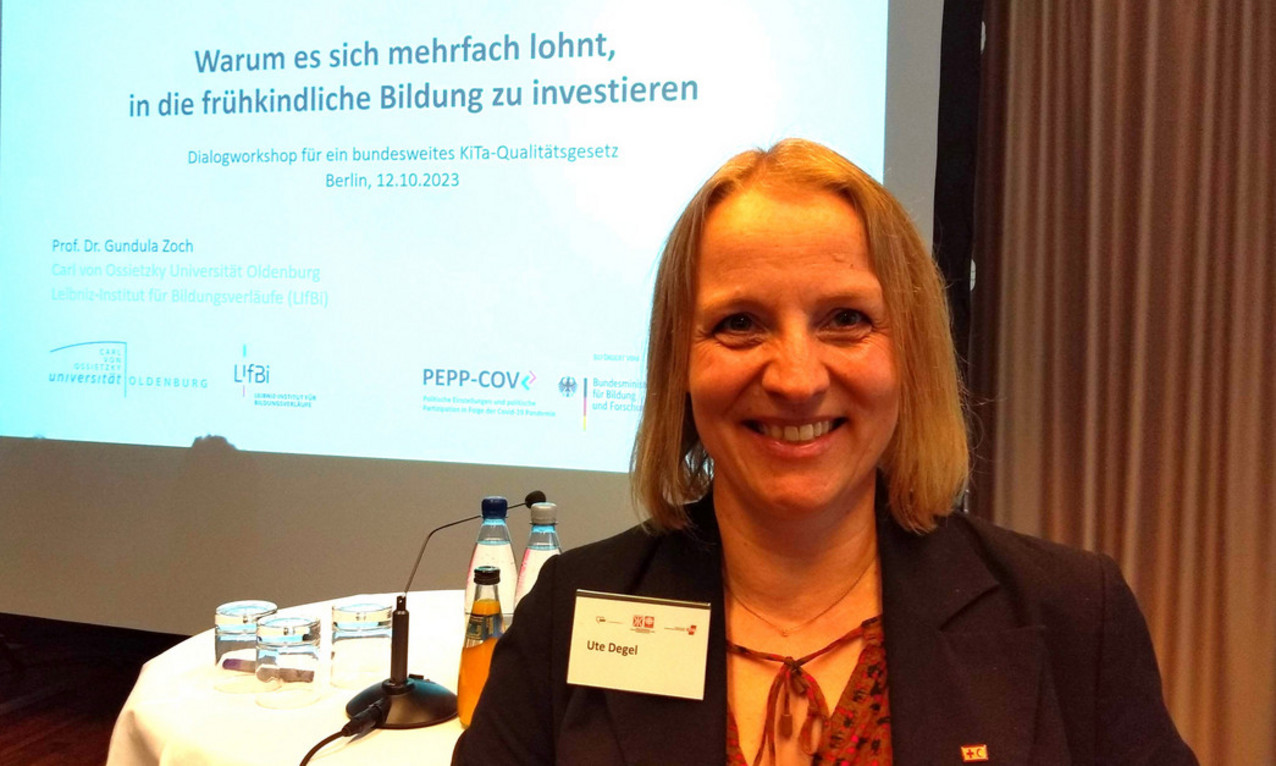 Frau steht vor Bildschirmpräsentation