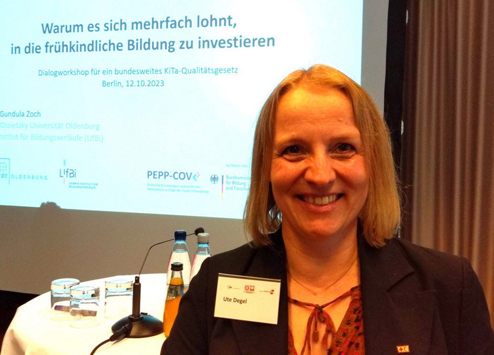 Frau steht vor Bildschirmpräsentation