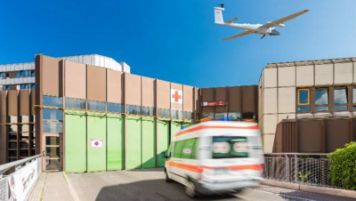 Symbolbild mit einem Krankenwagen, der auf ein Krankenhaus zufährt.
